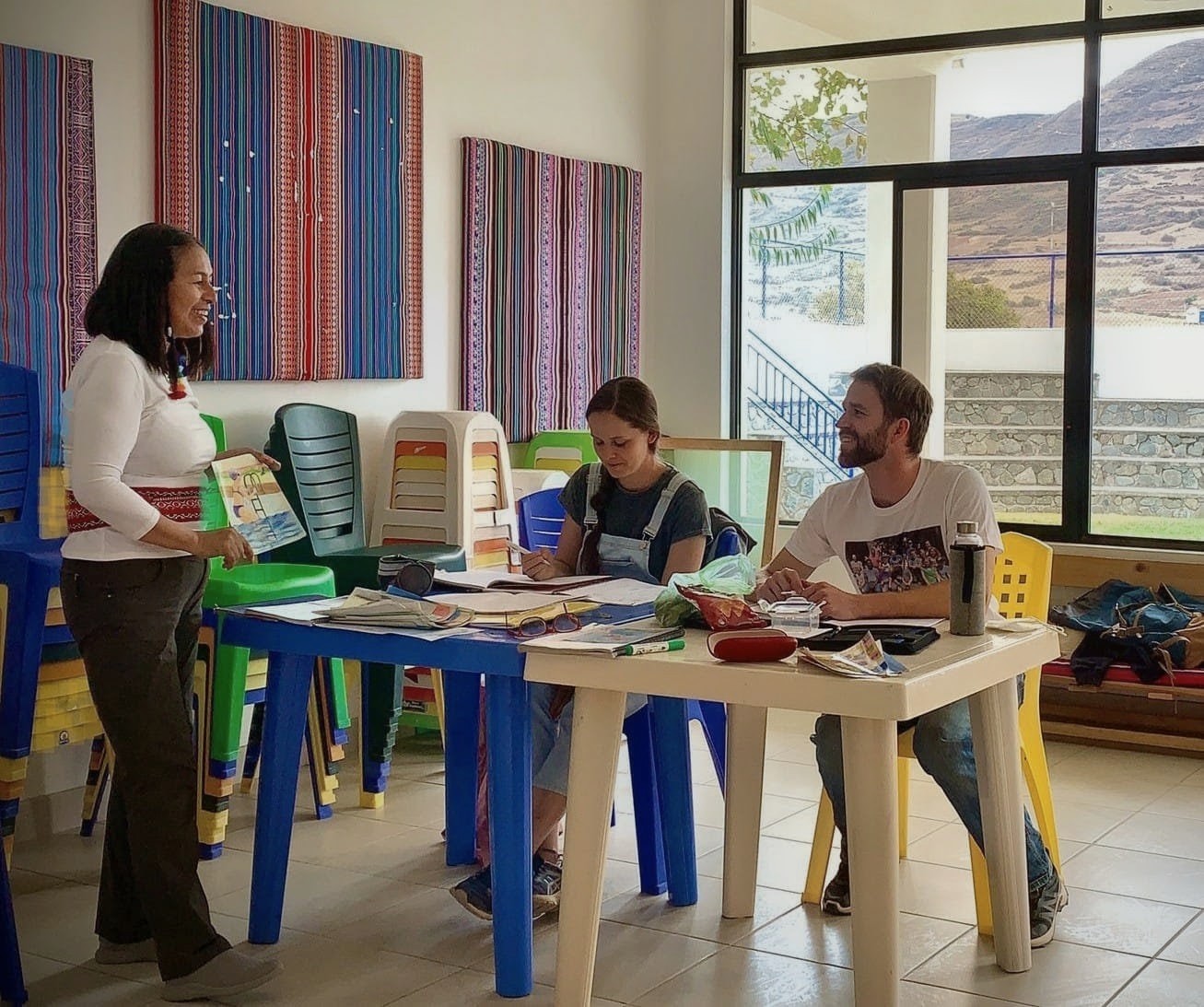 Charo Meneses enseñando español a dos estudiantes en el aula